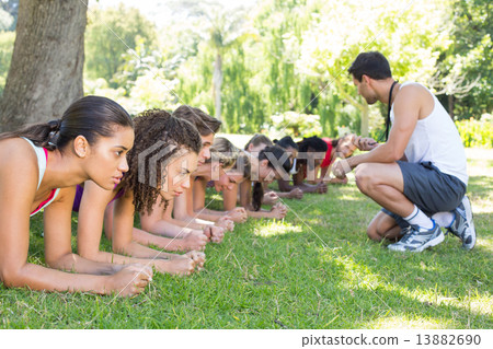 Fitness group planking in park with coach 13882690