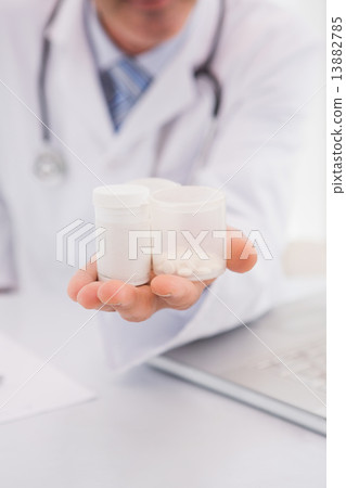 Doctor holding pills bottles Doctor holding pills bottles 13882785