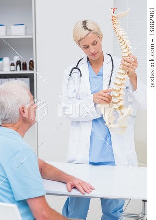 Doctor explaning spine model to patient in hospital Doctor explaning spine model to patient in hospital 13882981