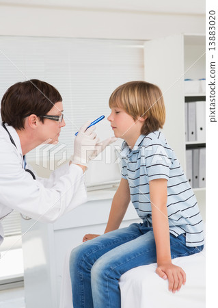 Doctor examines little boy with a light Doctor examines little boy with a light 13883020
