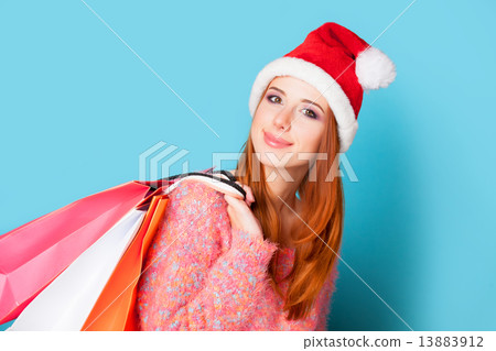 Redhead girl with shopping bags on blue background. 13883912
