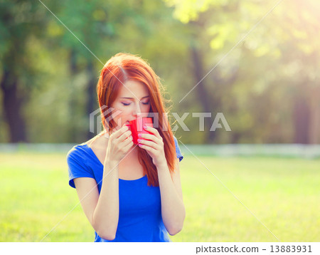 Redhead girl with orange cup at outdoor 13883931
