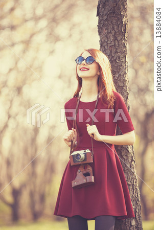 Redhead women in a park with camera Redhead women in a park with camera 13884084