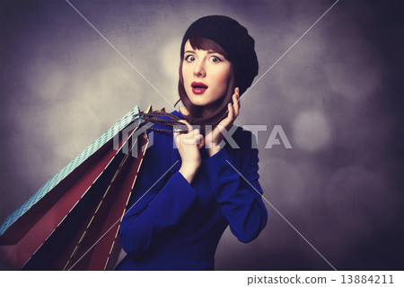 women in blue dress with shopping bags 13884211