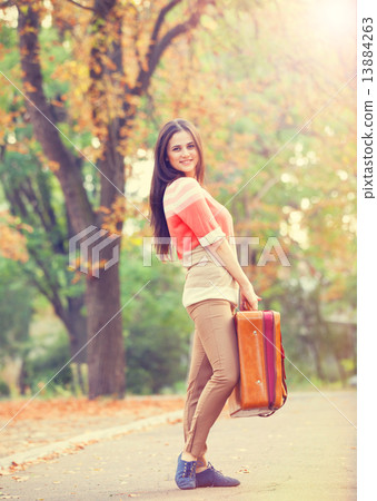 Beautiful brunette girl with suitcase in the park. Beautiful brunette girl with suitcase in the park. 13884263