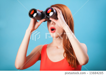 Redhead girl with binocular on blue background. 13884285