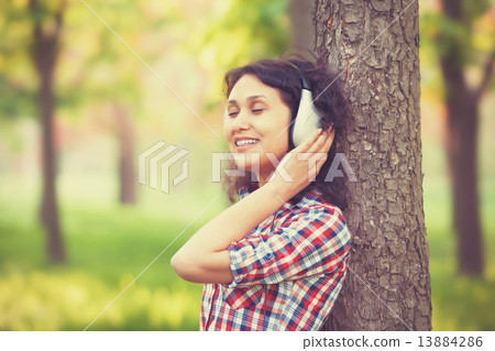 Indian girl with headphones in the park. Indian girl with headphones in the park. 13884286