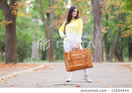 Beautiful brunette girl with suitcase in the park. 13884844
