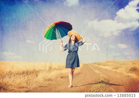 Brunette girl with umbrella on country side road. Brunette girl with umbrella on country side road. 13885015