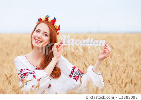 Redhead girl in national ukrainian clothes with wooden word Vaca Redhead girl in national ukrainian clothes with wooden word Vaca 13885098