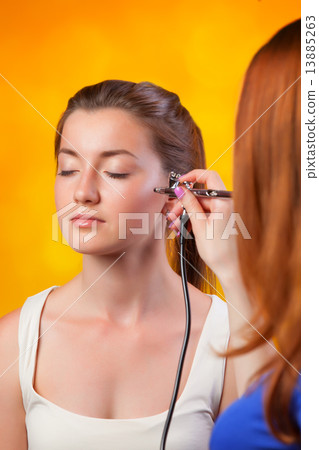 visagist making makeup for model with aerograph 13885263