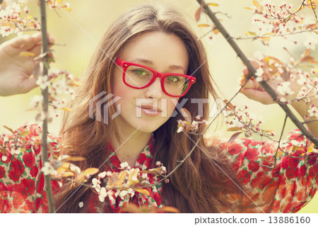 Teen girl in glasses near blossom tree 13886160