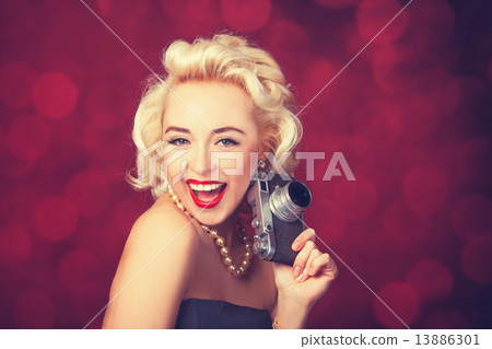 Beautiful blonde women with camera on red background. Beautiful blonde women with camera on red background. 13886301