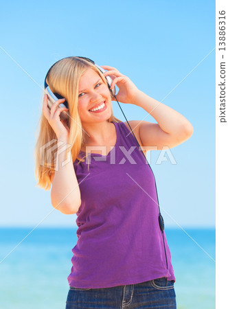 Portrait of blonde girl with headphone on the beach. Portrait of blonde girl with headphone on the beach. 13886316