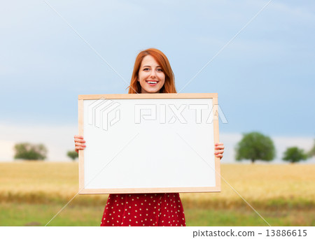 Redhead girl with blackboard at wheat field Redhead girl with blackboard at wheat field 13886615