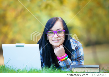Teen girl with laptop in the park. Teen girl with laptop in the park. 13887365