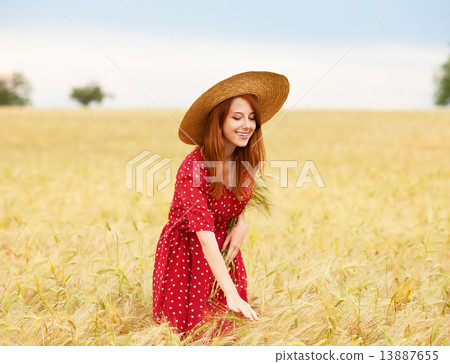 Redhead girl in red dress at wheat field Redhead girl in red dress at wheat field 13887655