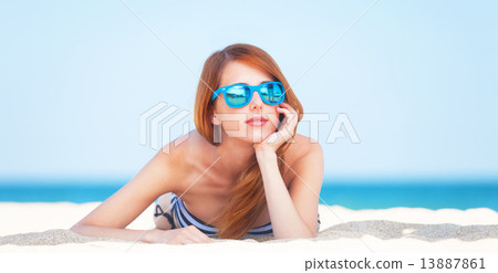 Redhead girl on the beach in spring time. Redhead girl on the beach in spring time. 13887861