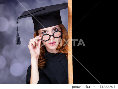 graduating student girl in an academic gown near blackboard graduating student girl in an academic gown near blackboard 13888201