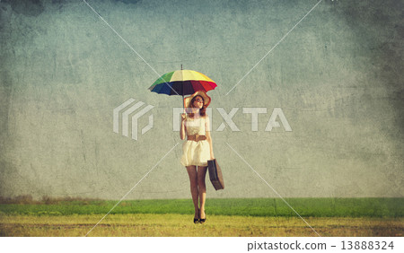 Redhead enchantress with umbrella and suitcase at spring country 13888324