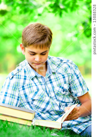 Teen boy with books and notebook in the park. 13888328