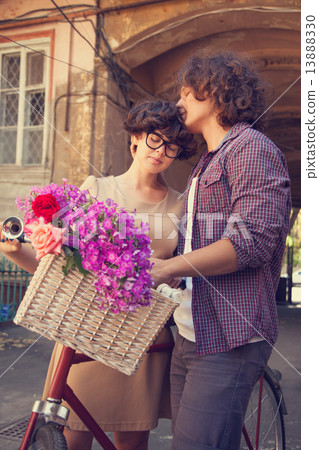 Couple with bike near house. 13888330