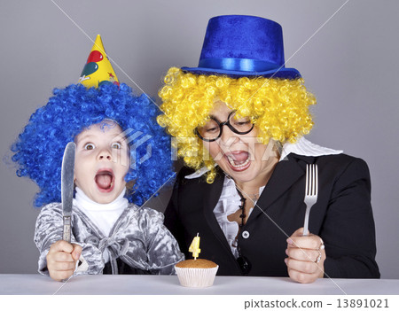 Mother and child in funny wigs and cake at birthday. Studio shot Mother and child in funny wigs and cake at birthday. Studio shot 13891021