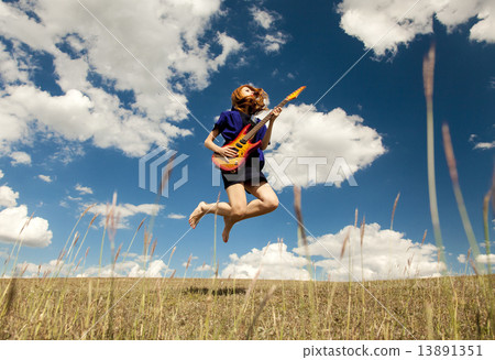 Redhead girl jumping with guitar at outdoor. Redhead girl jumping with guitar at outdoor. 13891351