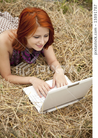 Young fashion girl with notebook lying at field 13891787
