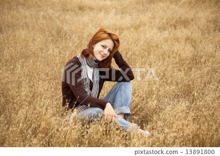 Beautiful red-haired girl at yellow autumn grass. Beautiful red-haired girl at yellow autumn grass. 13891800