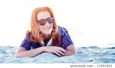 Beautiful redhead girl with headphones at beach sand. Beautiful redhead girl with headphones at beach sand. 13891802