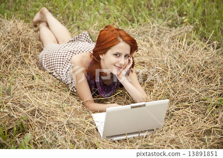 Young fashion girl with notebook lying at field 13891851
