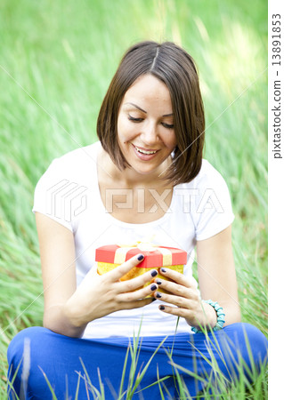 Beautiful teen girl with gift in the park at green grass. Beautiful teen girl with gift in the park at green grass. 13891853