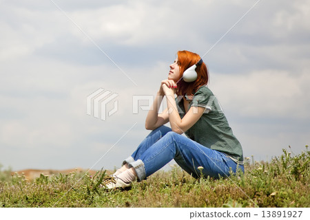 Young fashion girl with headphones at grass in spring time. 13891927