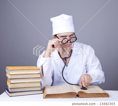 Young male doctor studying medical books 13892303