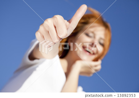 Portrait of red-haired girl in white which show hand OK symbol. 13892353