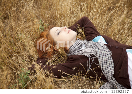 Young beautiful girl lying at yellow autumn field. 13892357