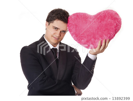 A man holding toy heart in formal black tux with tie isolated on 13892399