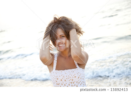 Pretty young woman standing on beach Pretty young woman standing on beach 13892413