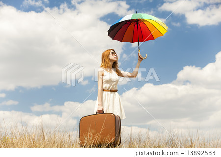 Beautiful redhead girl with umbrella and suitcase at outdoor. Beautiful redhead girl with umbrella and suitcase at outdoor. 13892533