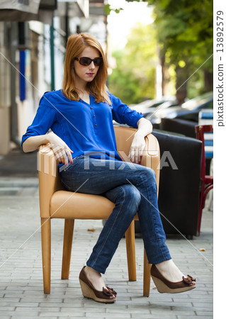 Style redhead girl sittin in the chair in the cafe 13892579