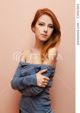 Beautiful redhead girl near wall. 13892802
