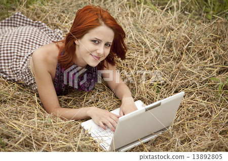 Young fashion girl with notebook lying at field 13892805