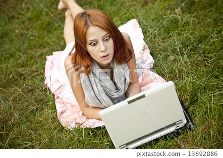 Young fashion girl with notebook lying at green grass Young fashion girl with notebook lying at green grass 13892886