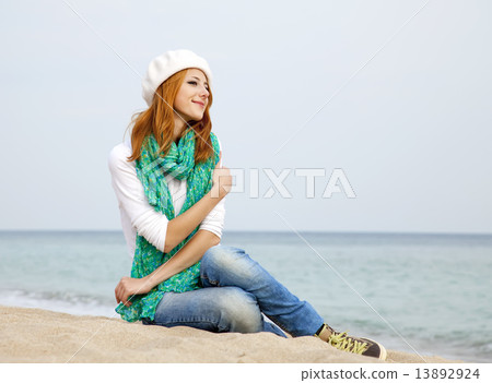 Young beautiful girl sitting at the beach 13892924