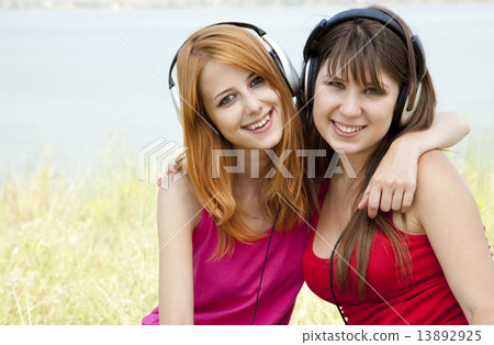 Two teenage girls listening to MP3 player Two teenage girls listening to MP3 player 13892925