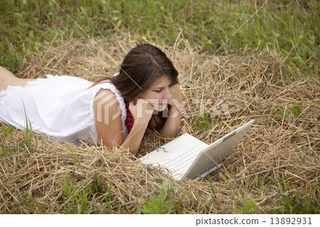 Young fashion girl with notebook lying at field 13892931