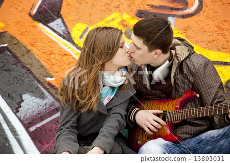 Teen couple kissing at graffiti background. Teen couple kissing at graffiti background. 13893031
