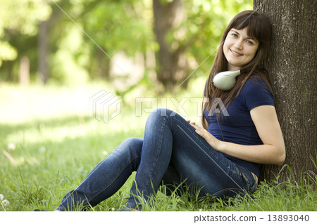Young fashion girl with headphones at green spring grass. 13893040