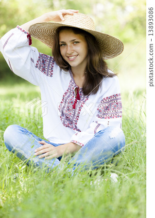 Slav teen girl at green meadow in national ukrainian clothing. 13893086